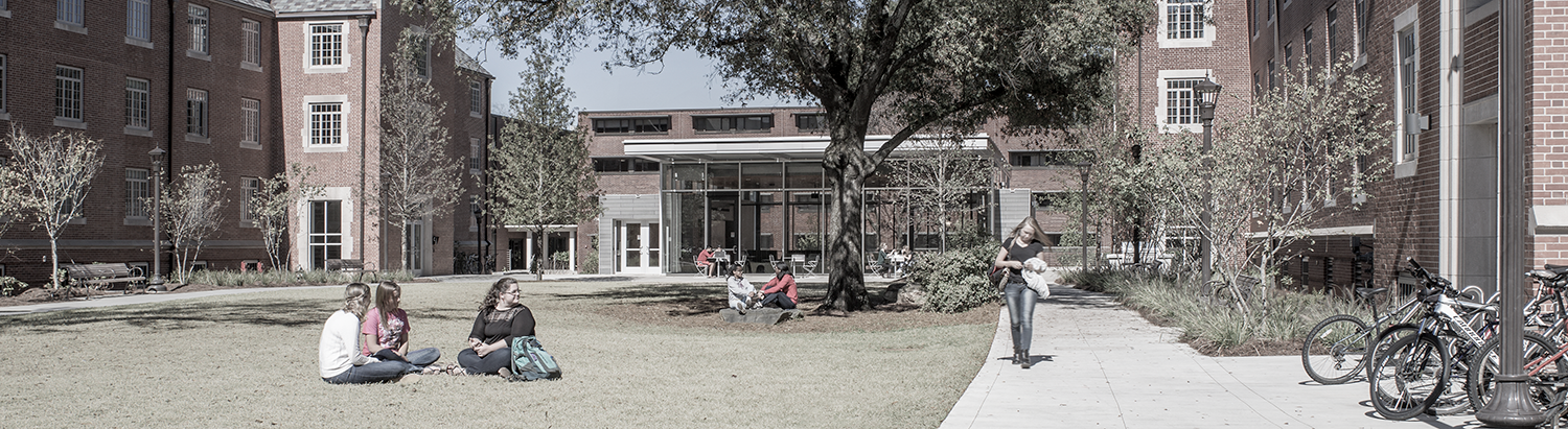 GT Housing buildings. Students walking and sitting on the lawn.